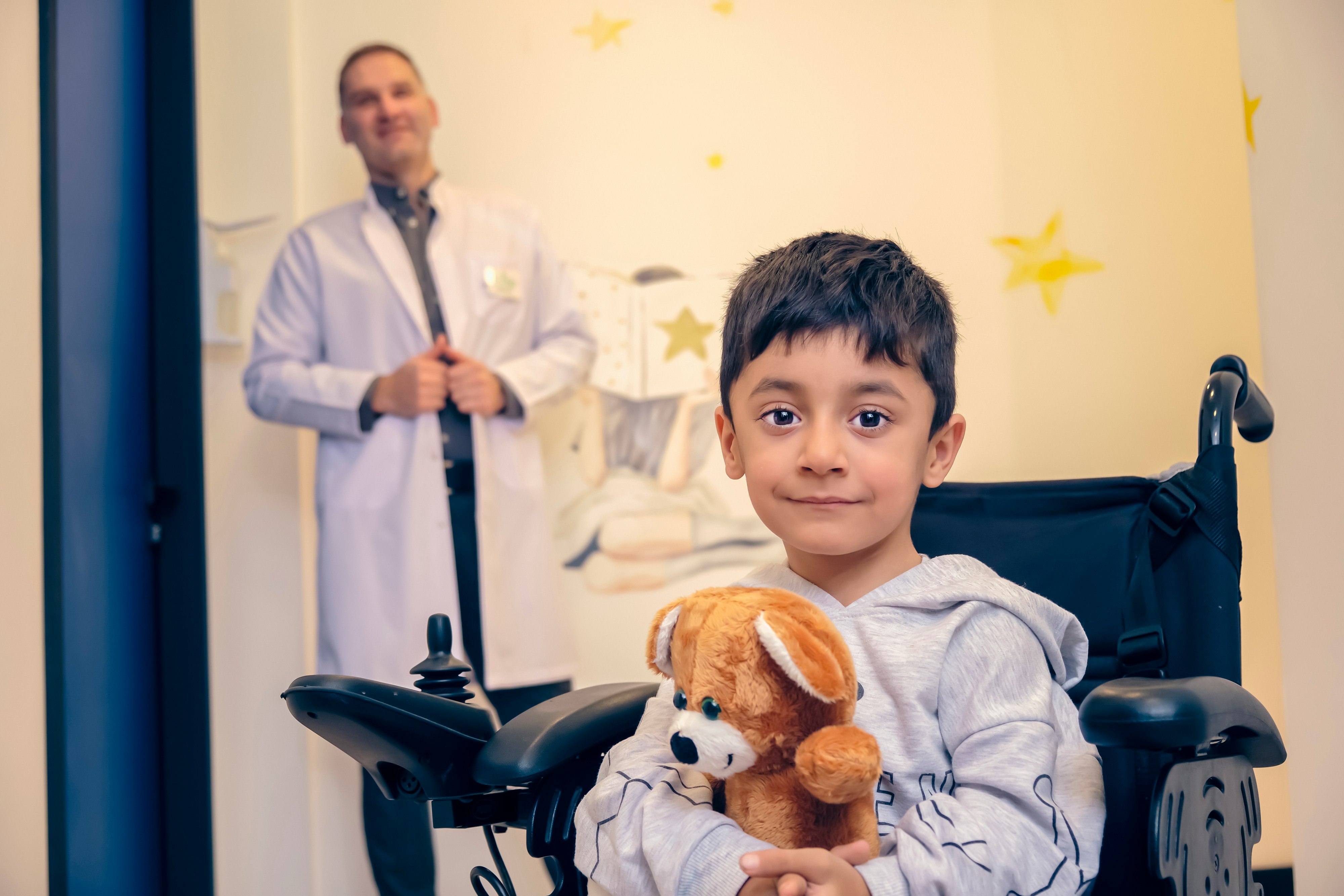 Child with stuffed animal in front of pediatrician in children's hospital